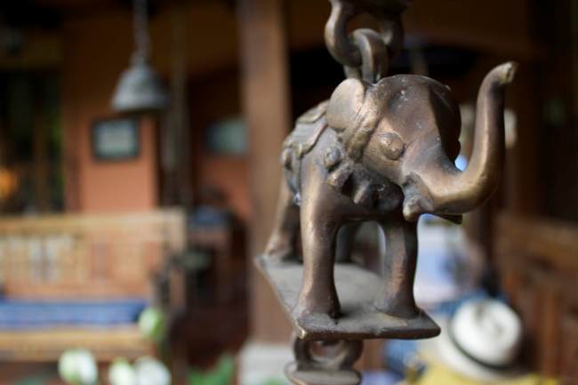 An elephant on a chain that supports a bench swing.