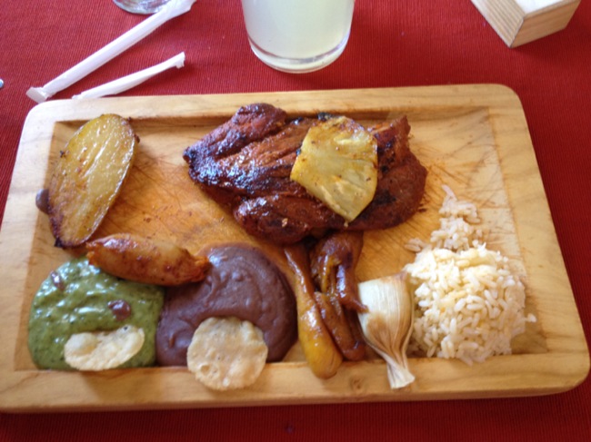 Traditional Mayan lunch, with roasted pork, tamales, rice, guacamole, refried beans, rice and potato.