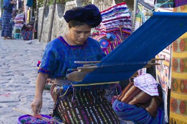 A woman weaving a hiupul in Santa Catarina, wearing a blue hiupul, which is common to the woman of the town