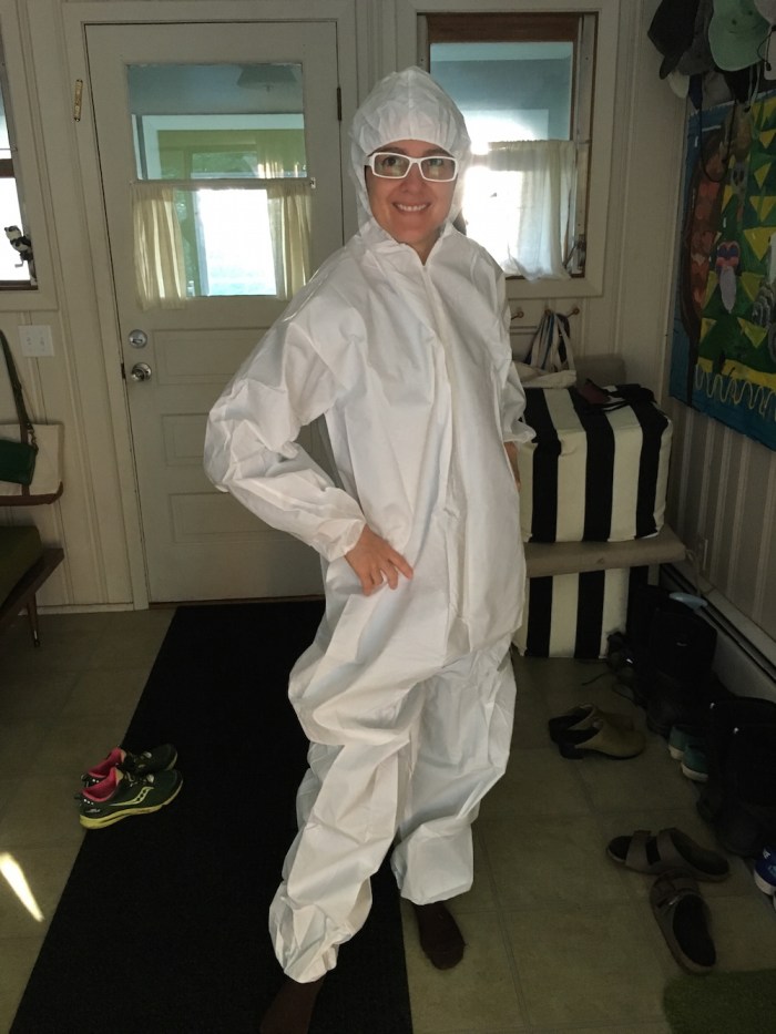 Deborah Zlotsky wears white coveralls before picking poison ivy